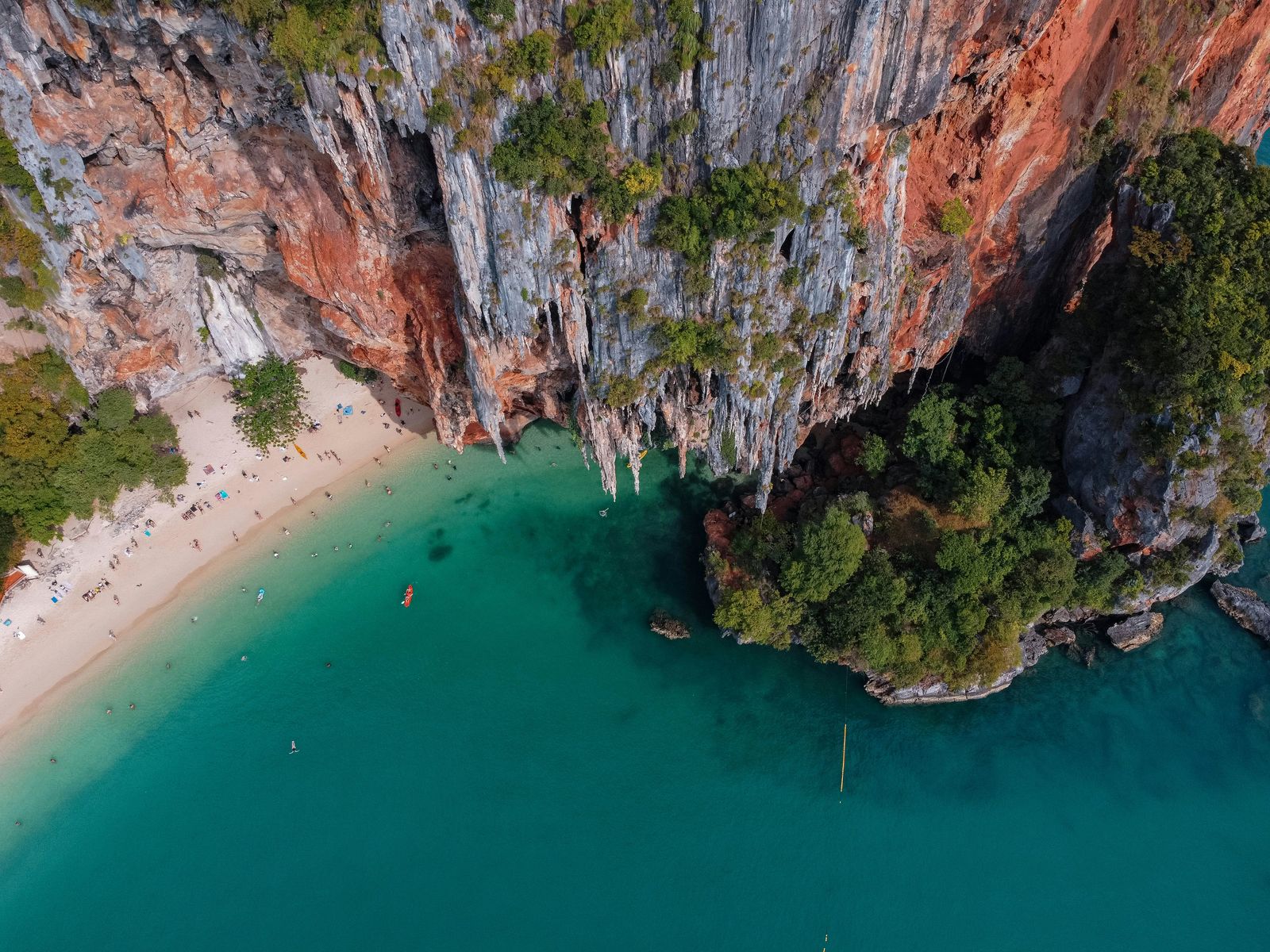 An aerial view of limestone cliffs, pale sand, and turquoise water at Railay.