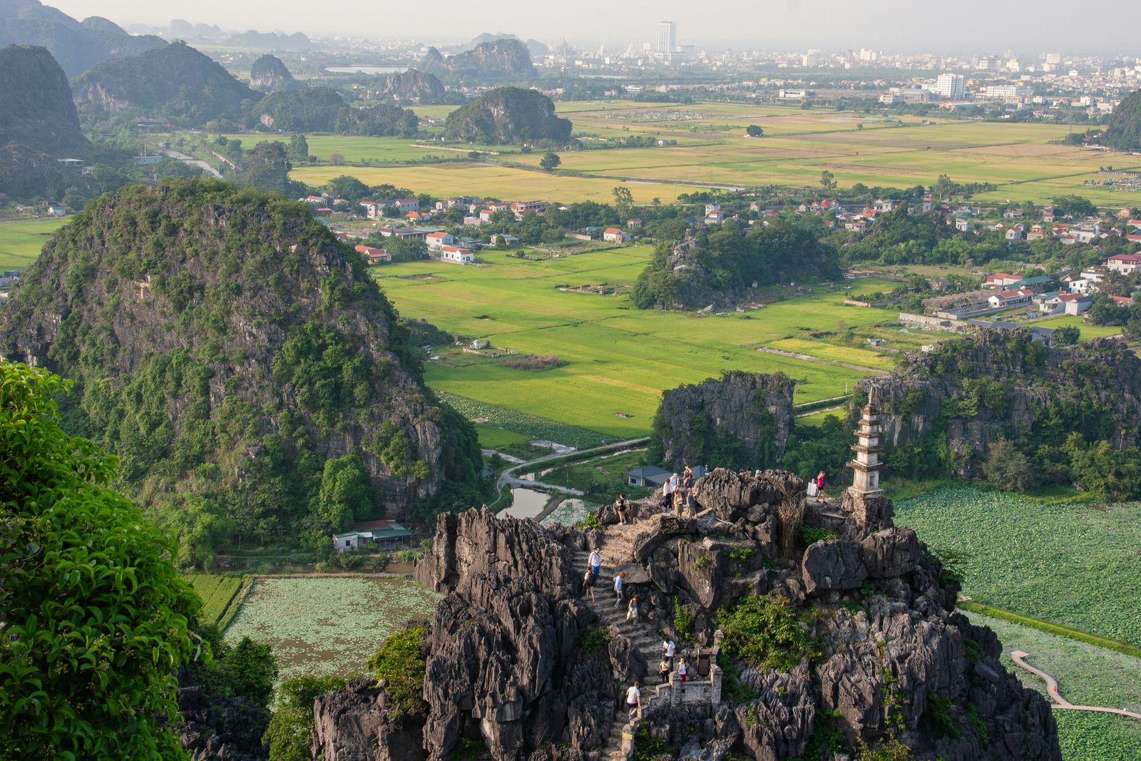 Limestone peaks and a small pagoda overlook the green rice fields of Ninh Binh.